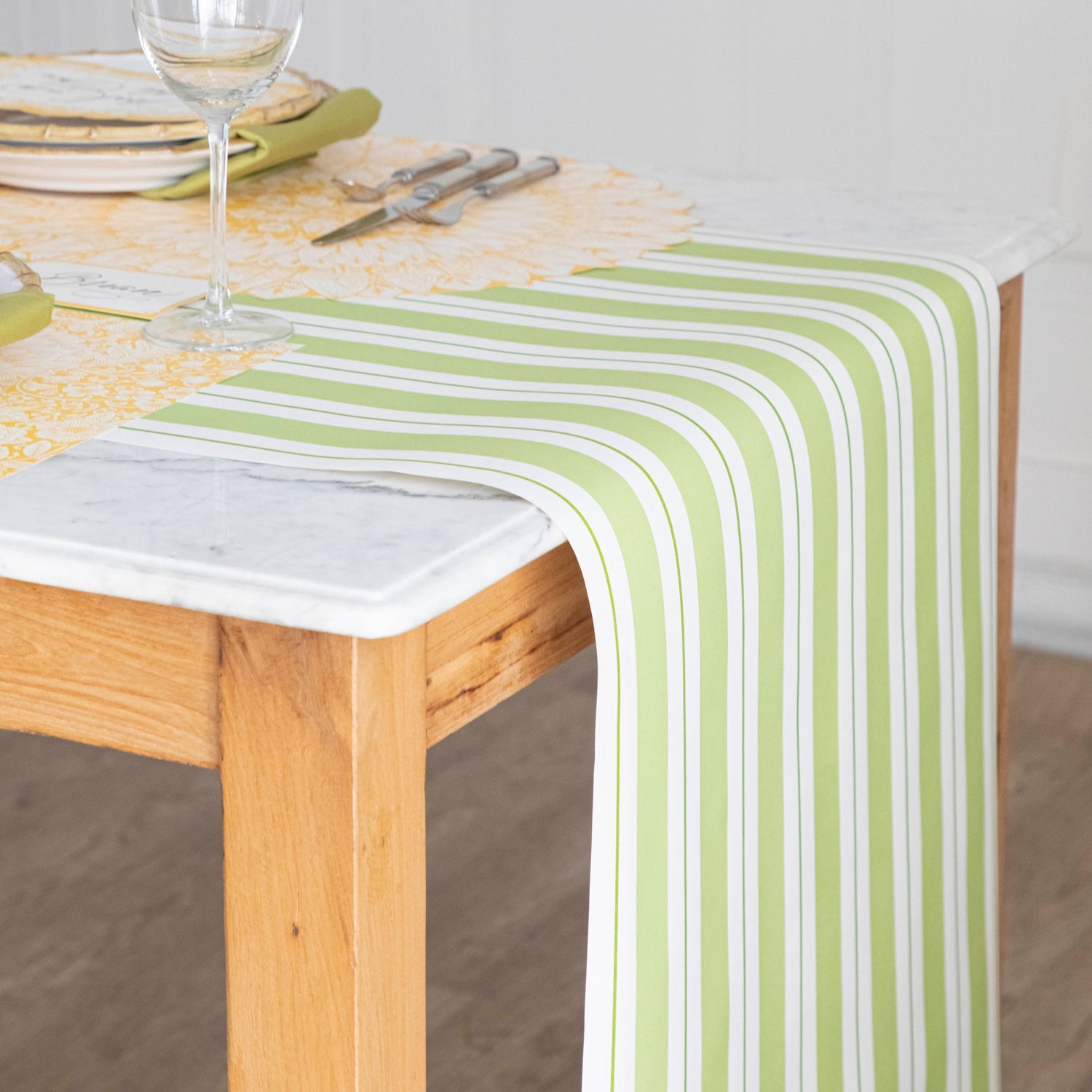 Green Awning Stripe Runner under a table setting, rolled off the side of the table to the ground.