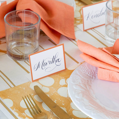 Orange Frame Place Card with &quot;Martha&quot; written in the white space, behind an elegant place setting.