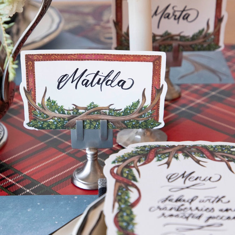 Close-up of an Antler Frame Place Card for &quot;Matilda&quot; in a place card stand, as part of a festive winter tablescape.