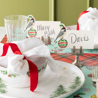 The Christmas Chickadee Place Card behind a festive place setting.