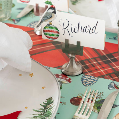 The Christmas Chickadee Place Card with the name &quot;Richard&quot; on it, being held up by the Silver Place Card Holder, on a festive place setting.