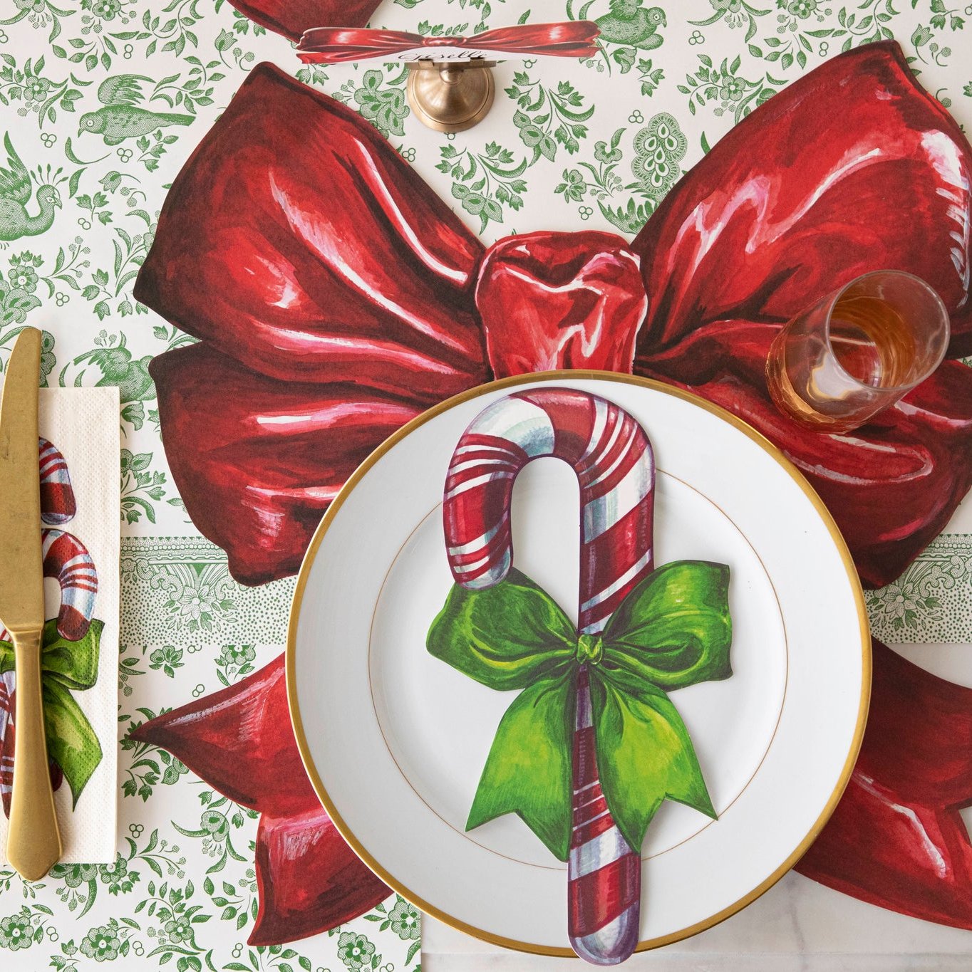 An elegant table setting featuring the Die-cut Christmas Bow Placemat paired with the Candy Cane Table Accent and Candy Cane napkins.