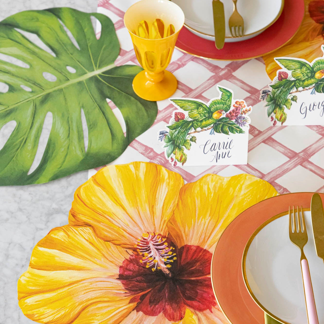 A tropical table setting with the Die-cut Monstera Leaf Placemat under a place setting.