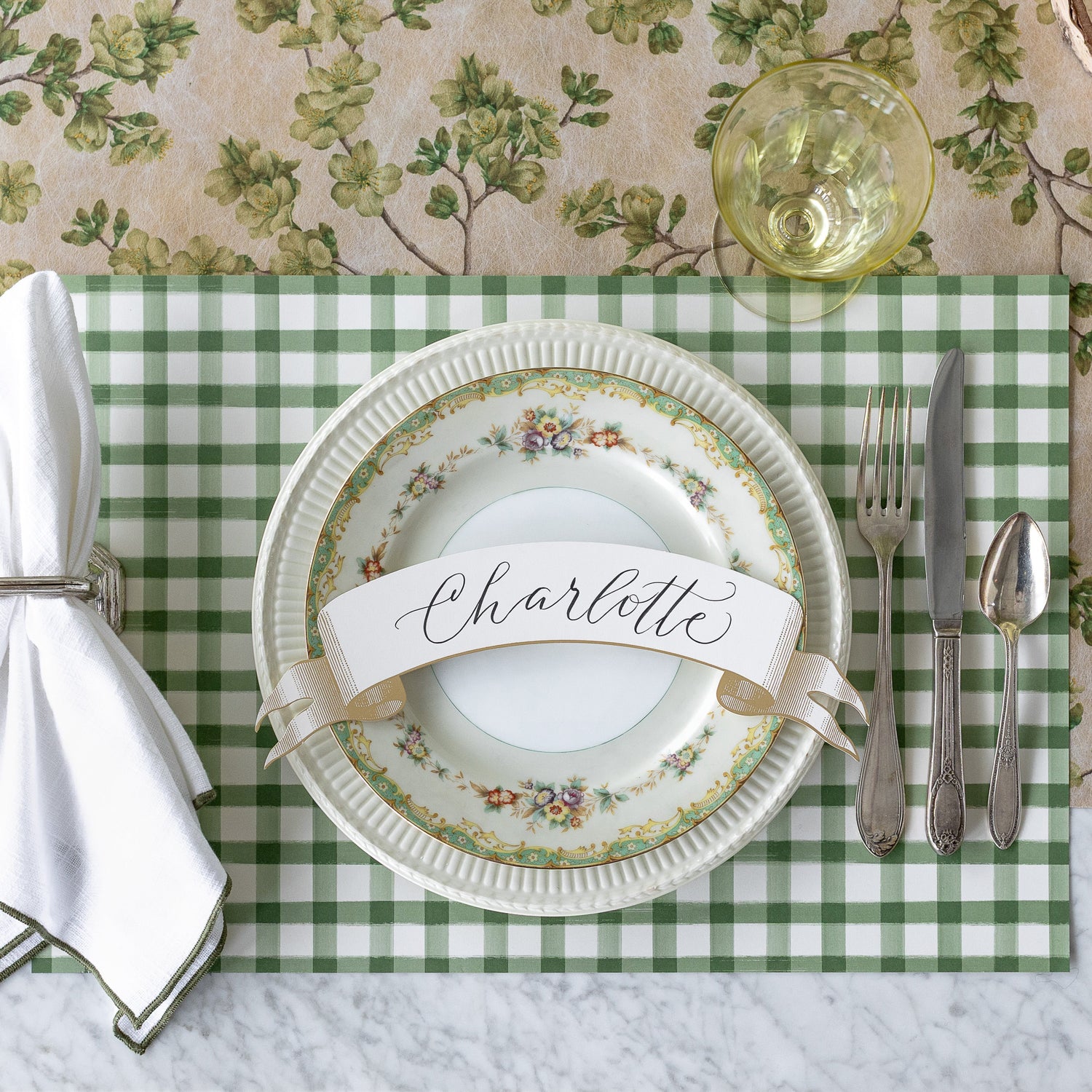 A place setting with the Dark Green Painted Check Placemat and Green Cherry Blossom Runner underneath.