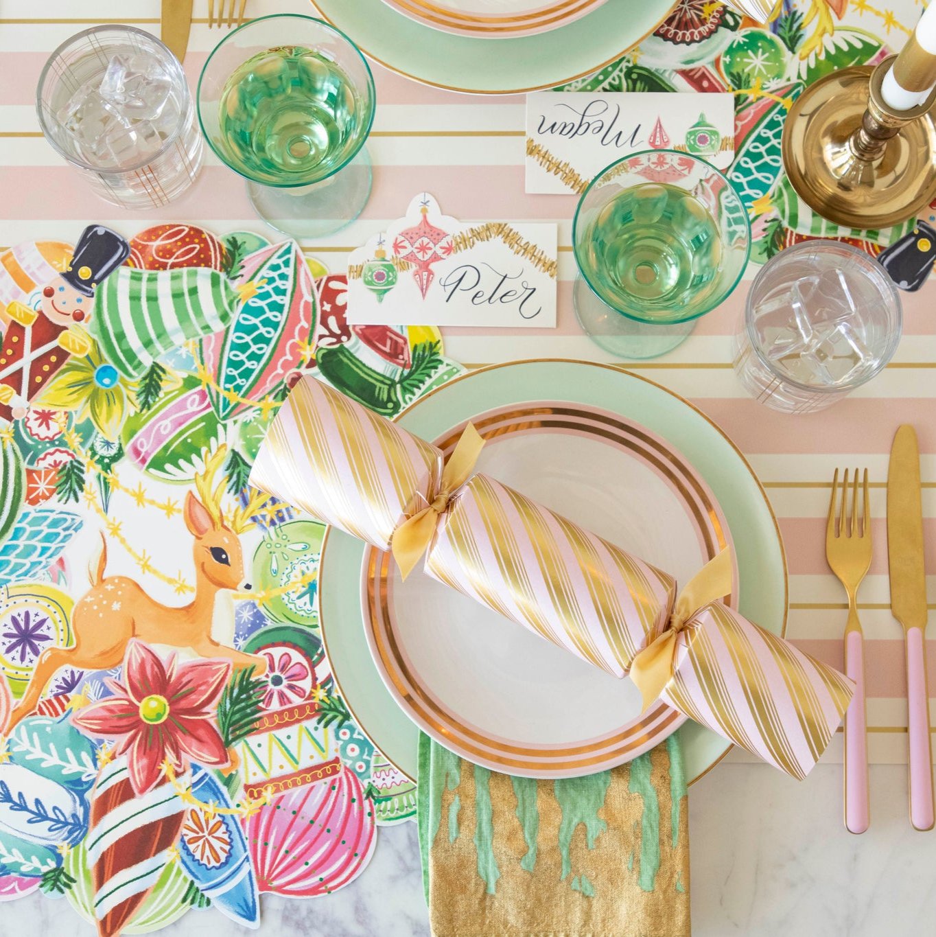 A nostalgic table setting featuring the Peppermint Stripe Cracker resting on top of dinner plates with the Die-cut Yuletide Treasure Wreath Placemat underneath.