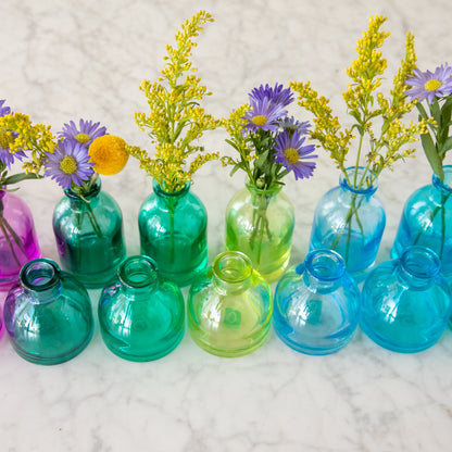 Tall and round Jewel Tone Glass Bud Vases ranging from colors green to blue.