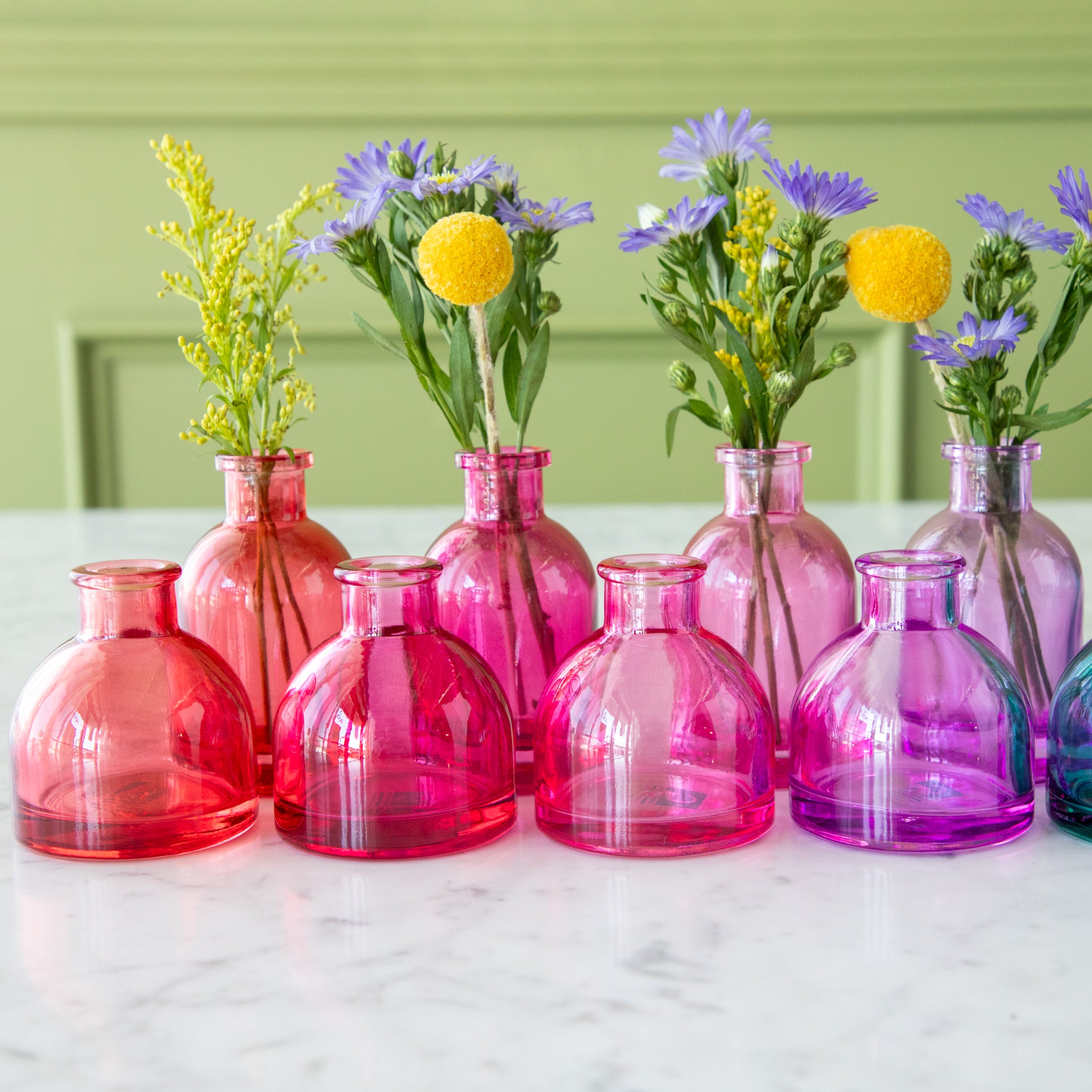 Tall and round Jewel Tone Glass Bud Vases ranging from colors red to purple.