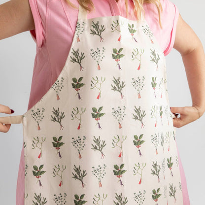 A woman tying the Laura Stoddart Christmas Apron behind her back.