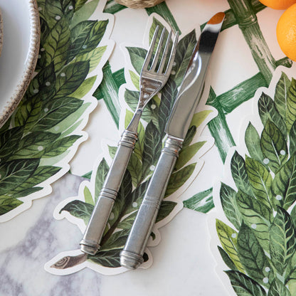 Laurel Table Accent under a fork and knife, on a place setting.