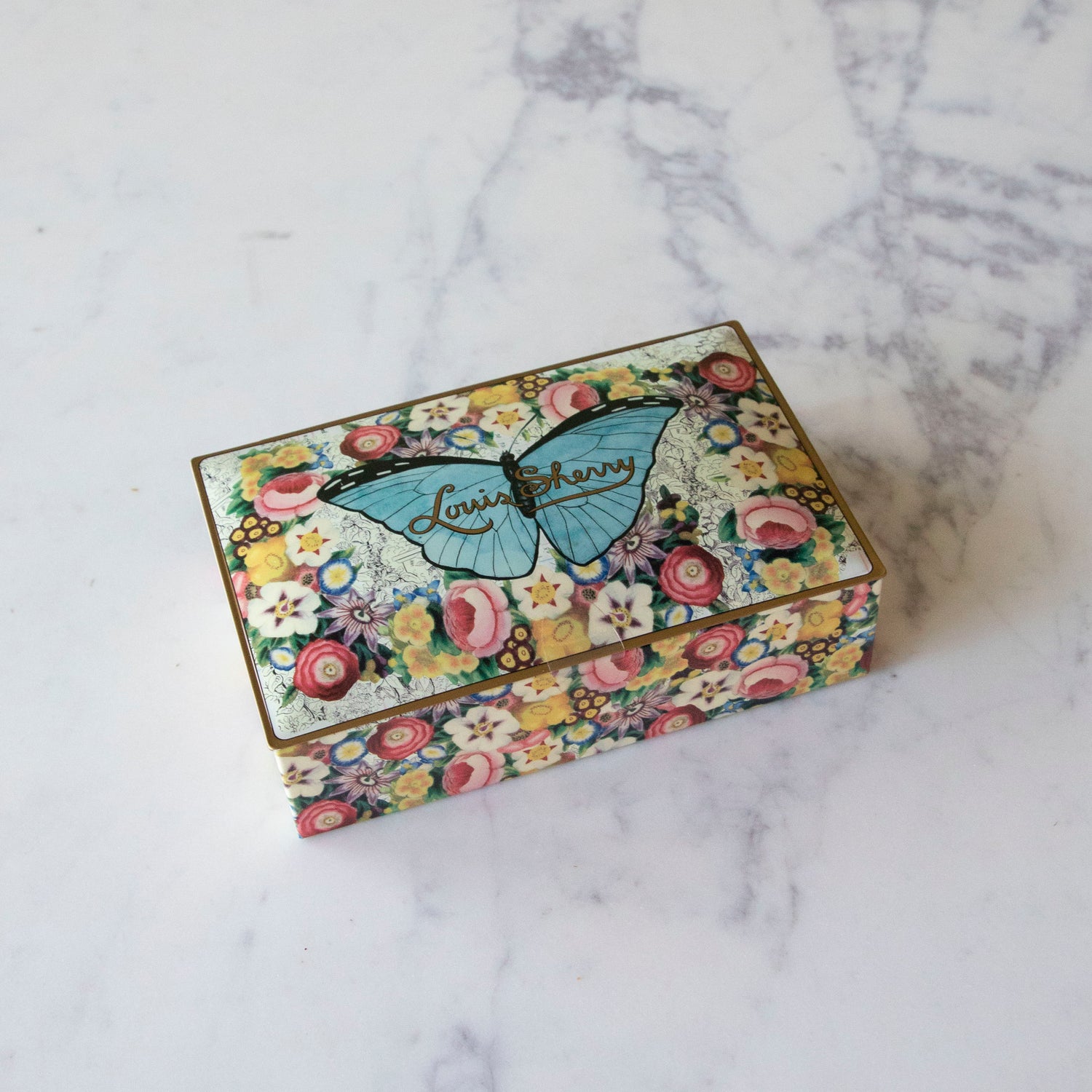 12-Piece John Derian Butterfly Louis Sherry Chocolate Box on a marble table.