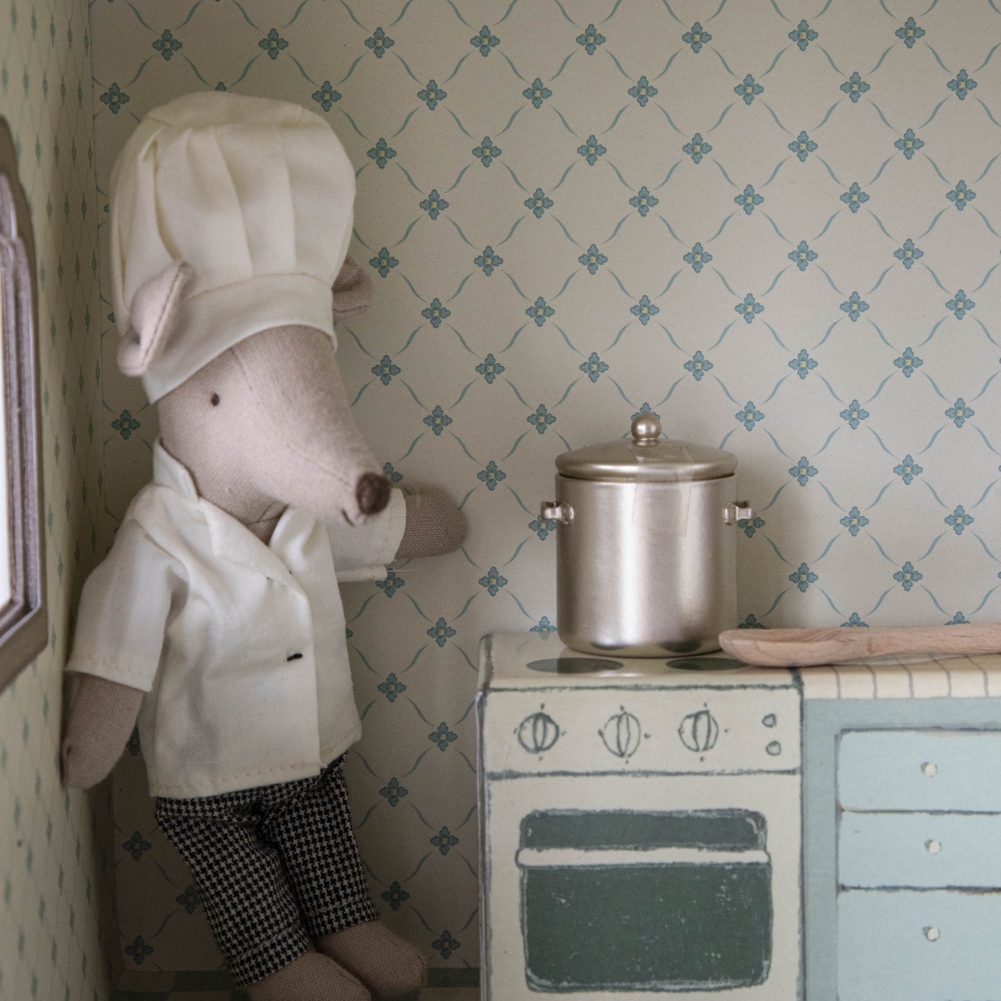 Chef Mouse with Soup Pot and Spoon from the Maileg kitchen collection dressed as a chef standing in a miniature playset environment.