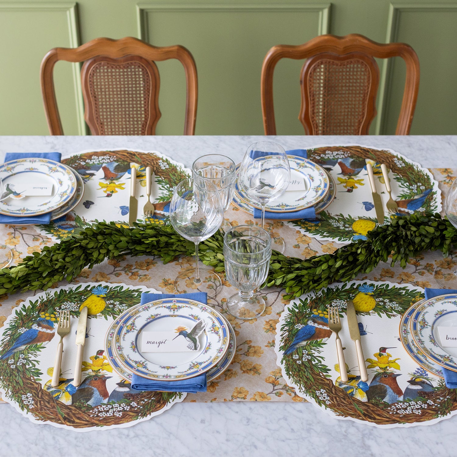 A garden themed table setting for four with the Marigold Cherry Blossom Runner under the Die-cut Songbird Wreath Placemat.