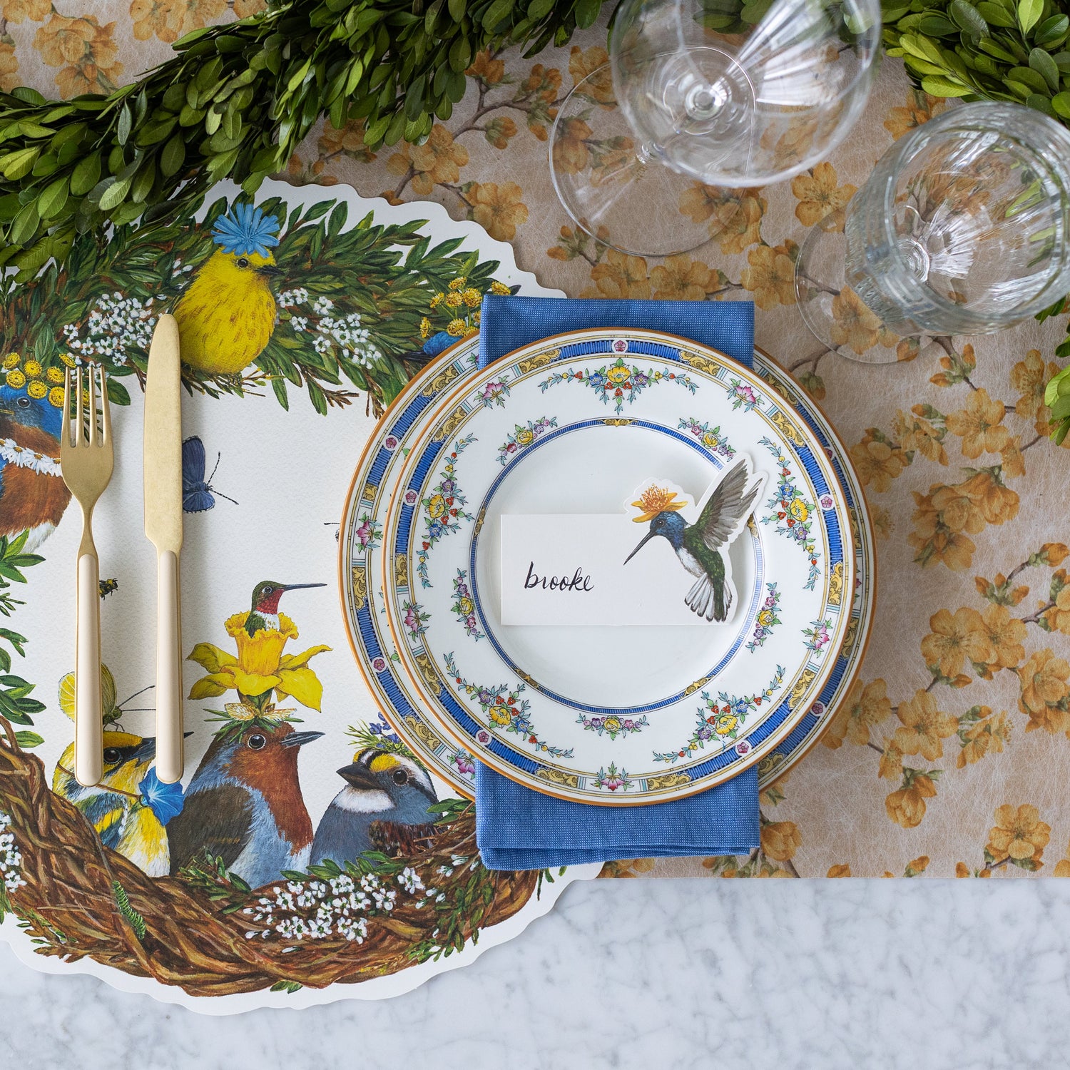 A garden themed table setting with the Marigold Cherry Blossom Runner under the Die-cut Songbird Wreath Placemat.