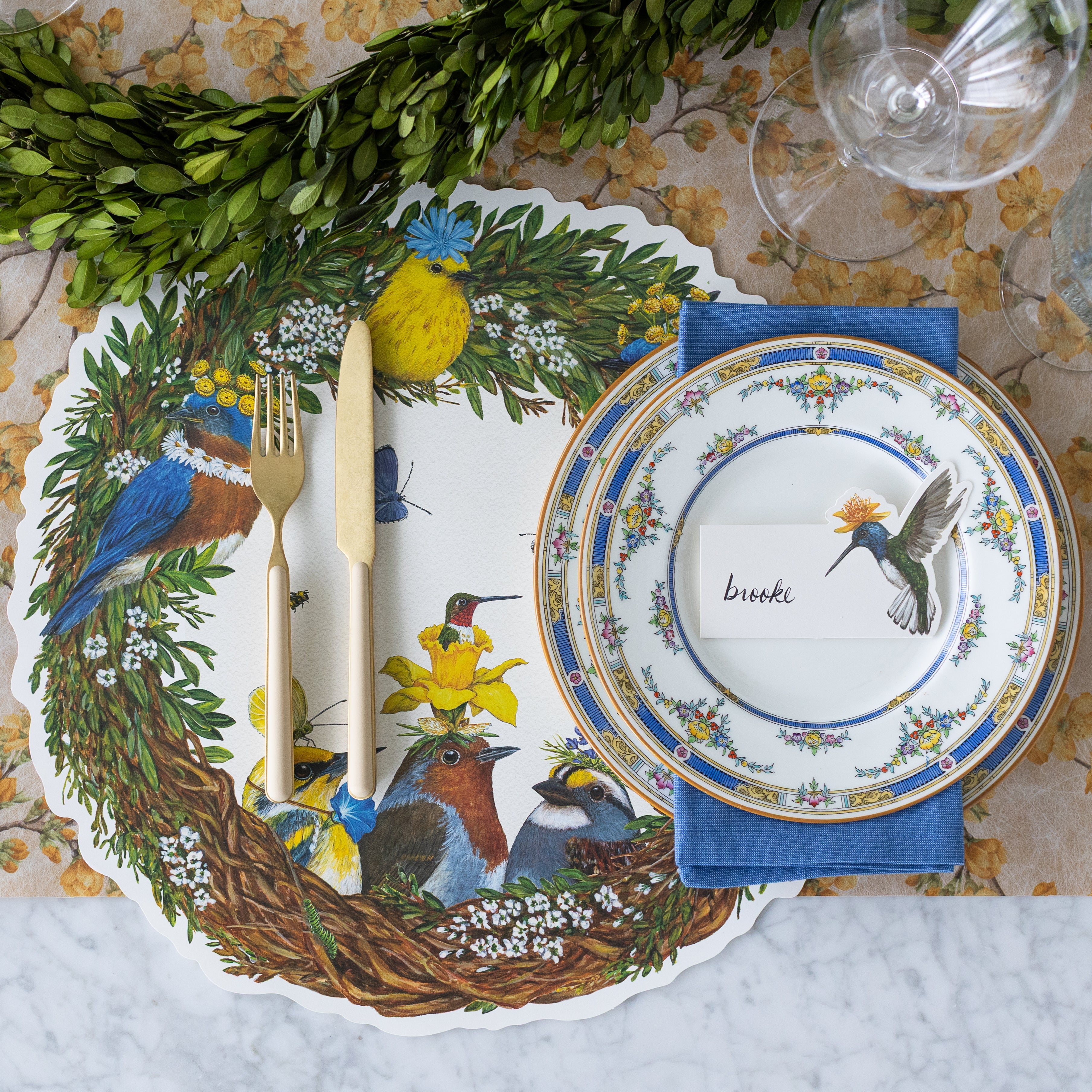 Hummingbird Place Card with &quot;brooke&quot; written on it, resting on plates on a garden themed place setting.