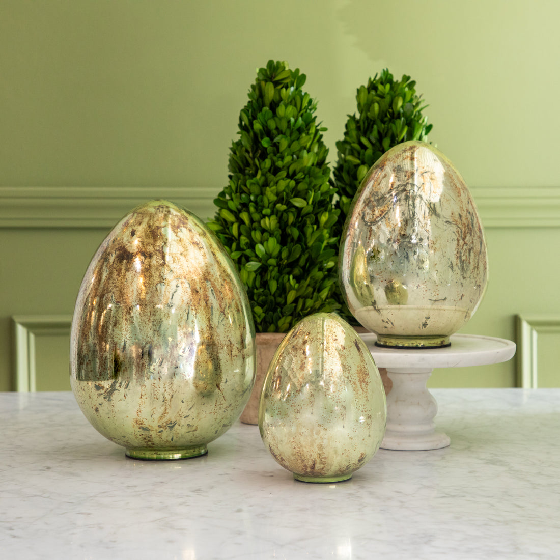 Mercury Glass Easter Eggs in three sizes styled on a table with topiary.