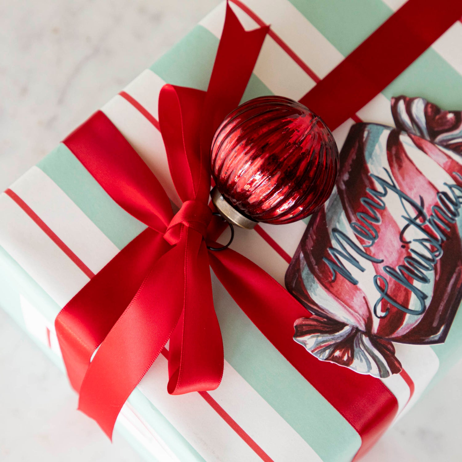 Mini red ribbed ornament strung on a red ribbon that&