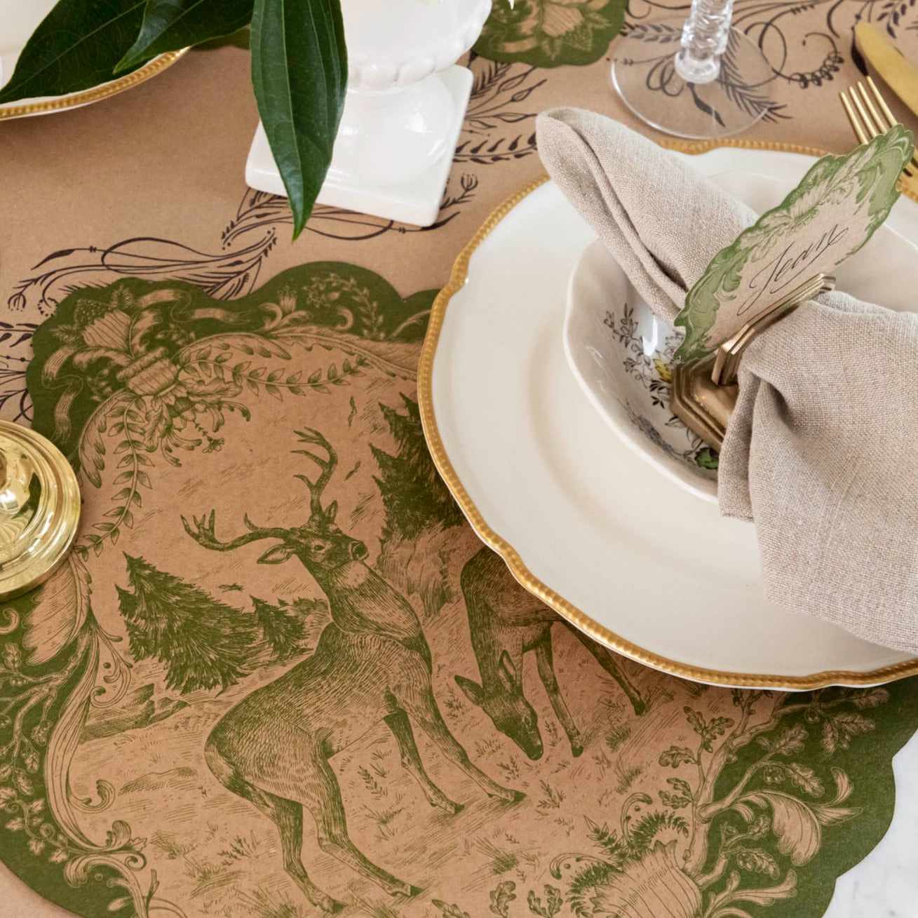 The Die-cut Moss Fable Fauna Placemat under an elegant place setting.