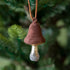 A Glass Mushroom with Velvet Top Ornament hanging on a tree.