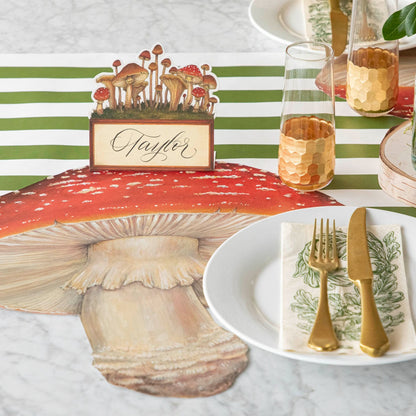 A table setting with elegant gold place settings next to a die-cut mushroom placemat.
