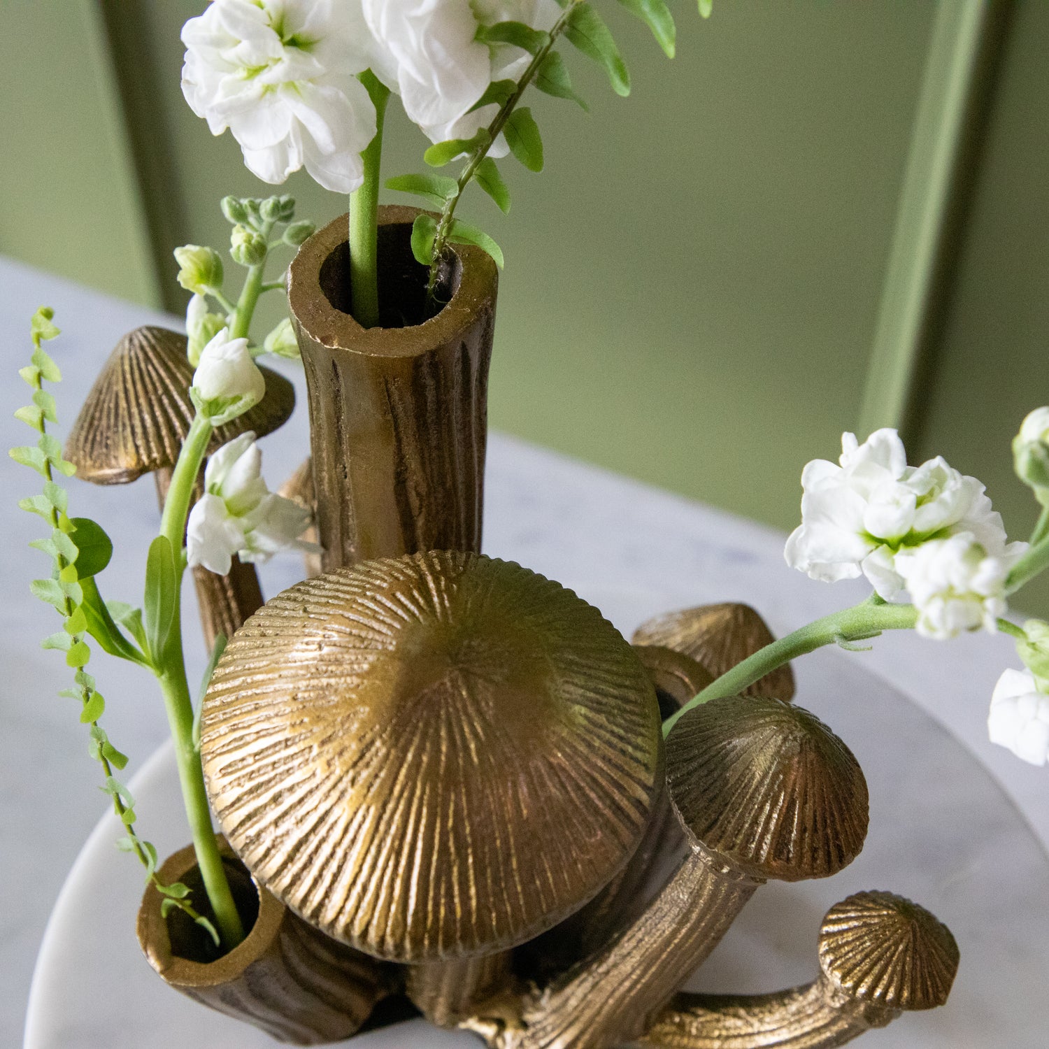 A top down view of the Clustered Mushroom Vase showing the open stems with flowers in them and mushroom caps.