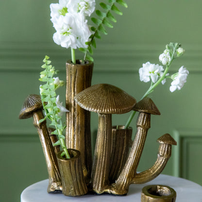  A Clustered Mushroom Budvases with flowers in it on a cake stand.