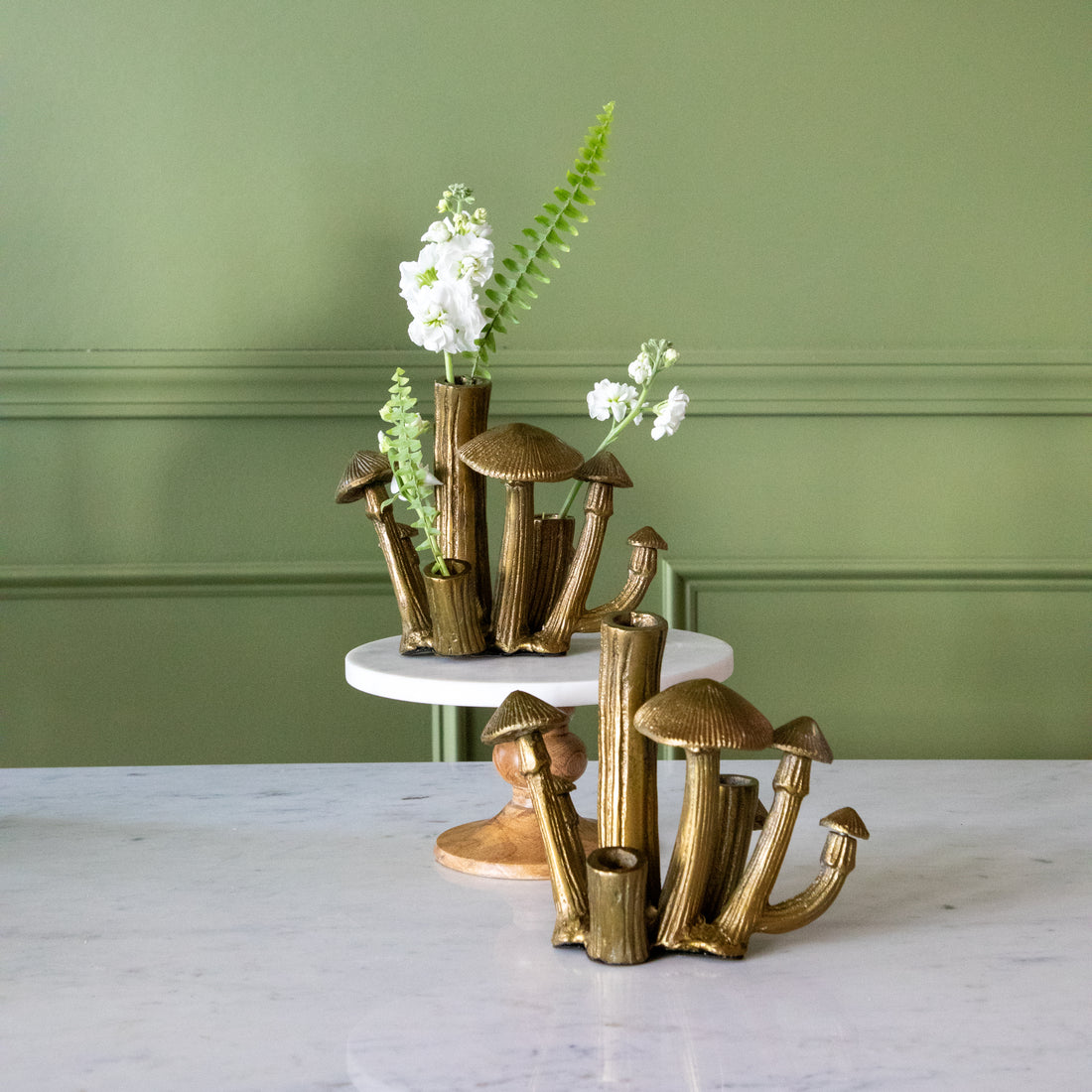 A Clustered Mushroom Budvase with flowers in it on a cake stand and another on the table.