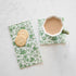 A cup of coffee and cookies on a white table adorned with Hester & Cook&