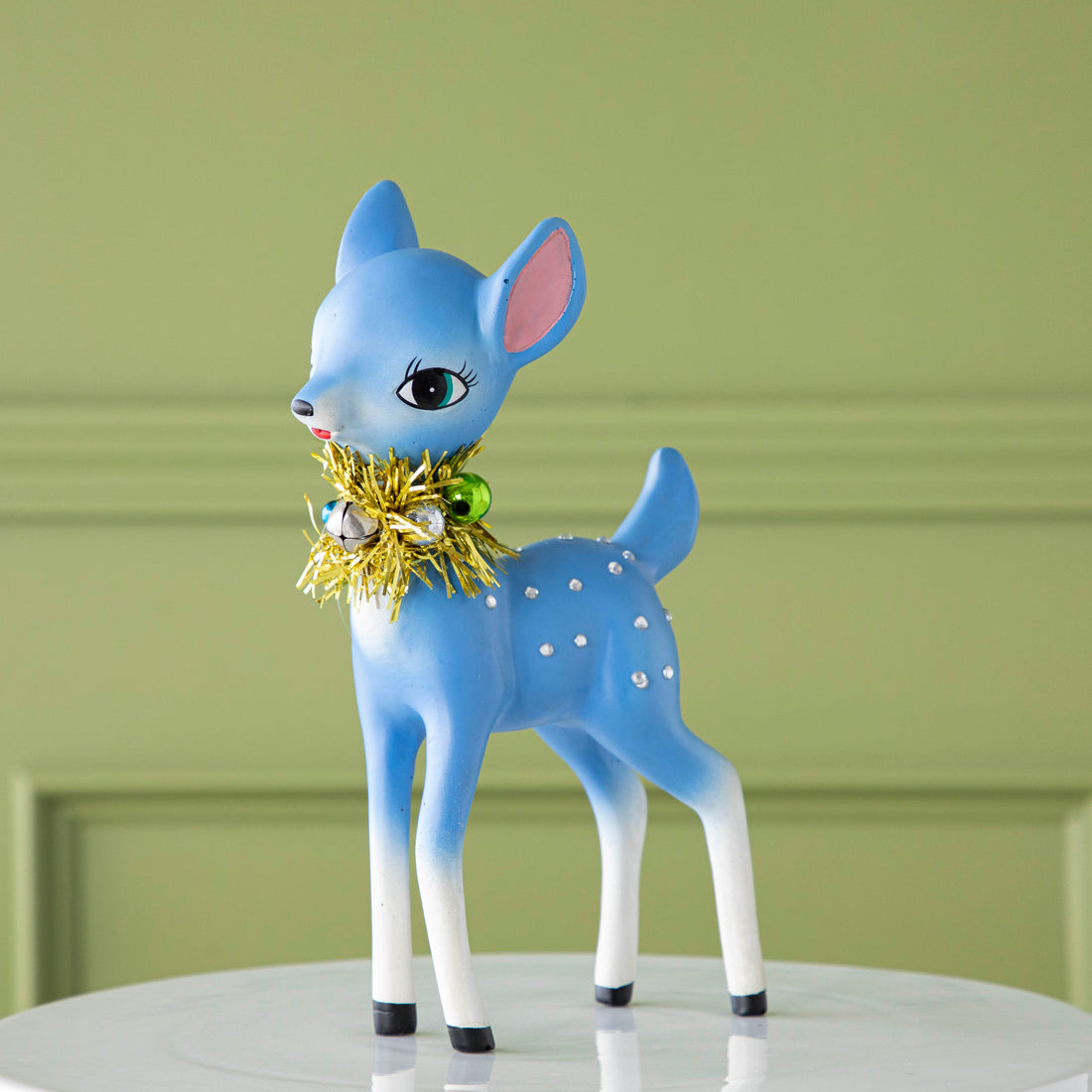 The blue, Retro Reindeer with a tinsel wreath with ornaments around its neck, and jeweled body.