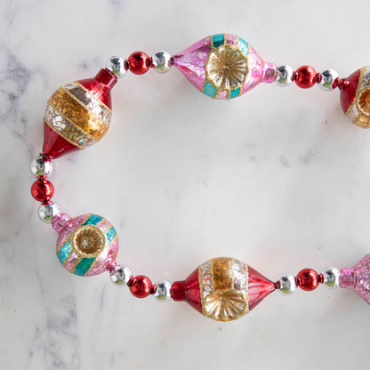 The  Retro Tinsel and Glass Finial Garland on a marble table.