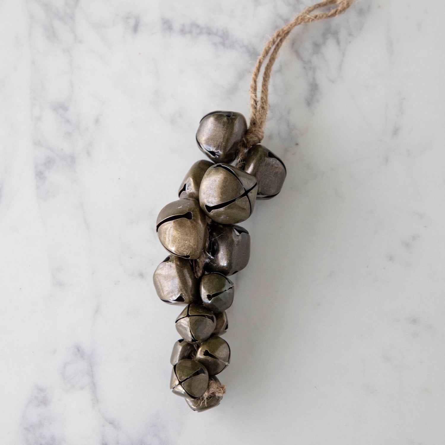 A Jingle Bells Ornament on a marble table.