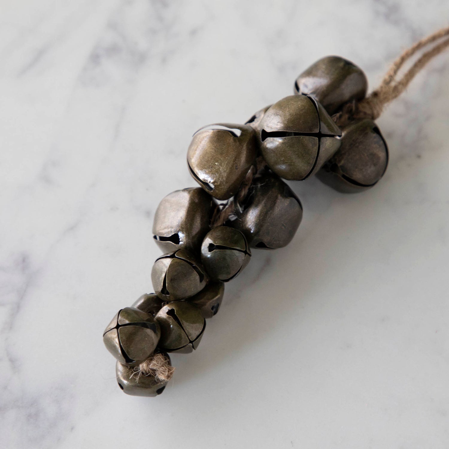 A Jingle Bells Ornament on a marble table.