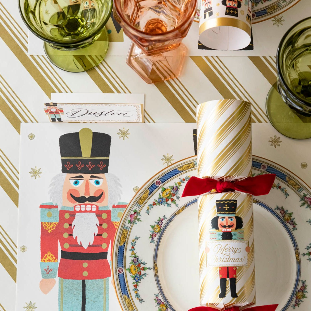 The Gold Peppermint Stripe Runner under an elegant table setting with the Nutcracker Cracker on a floral dinner plate, on top of the Nutcracker Placemat.