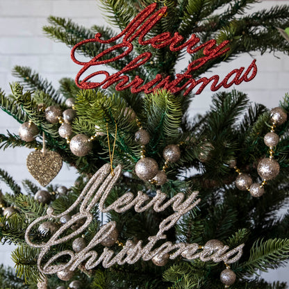 Champagne and red Merry Christmas ornament in a decorated tree.