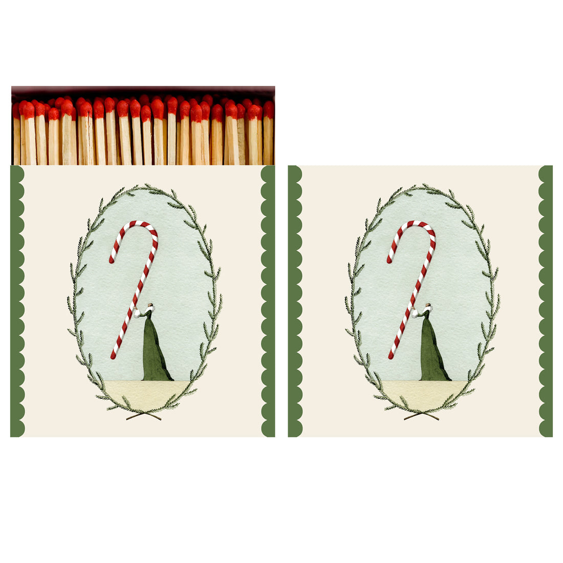 Two identical sides of a square match box, the left of which is open slightly to reveal the matches inside. The artwork on the box depicts a small woman in a green dress holding aloft a gigantic candy cane, surrounded by an oval frame of winter foliage on a cream background, with a green scalloped accents along the left and right sides.