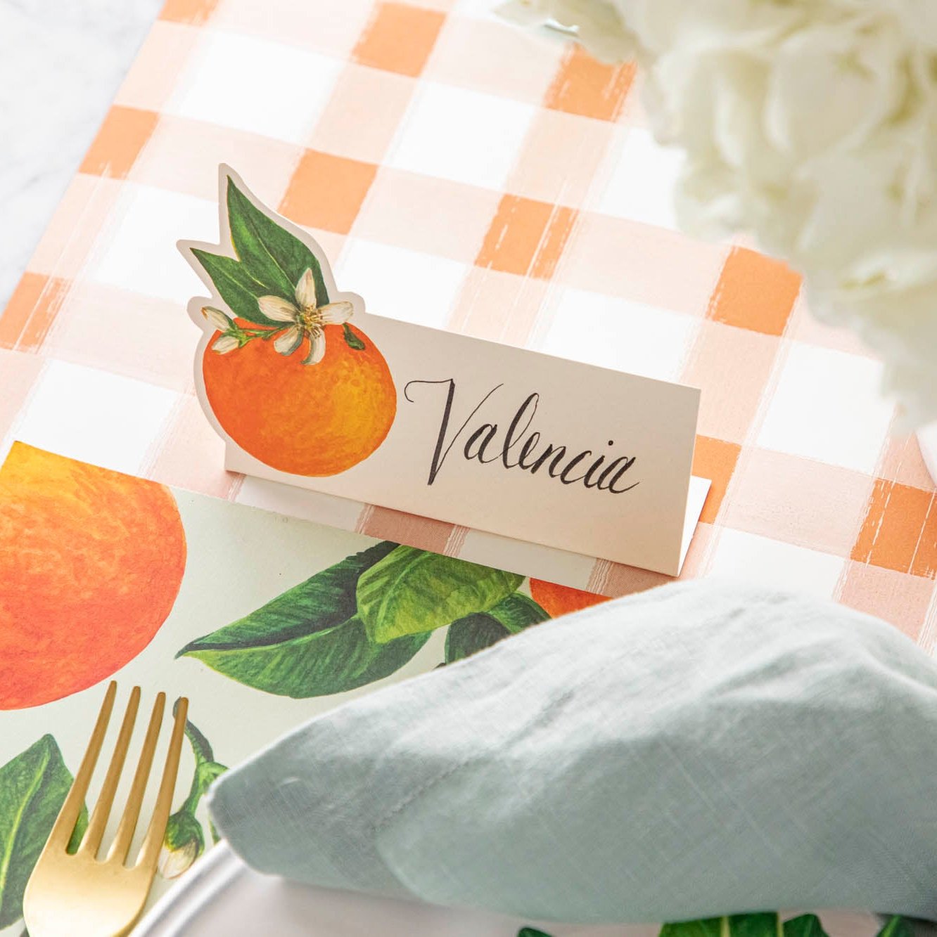 The Orange Blossom Place Card with &quot;Valencia&quot; written on it, on the Orange Painted Check Runner.