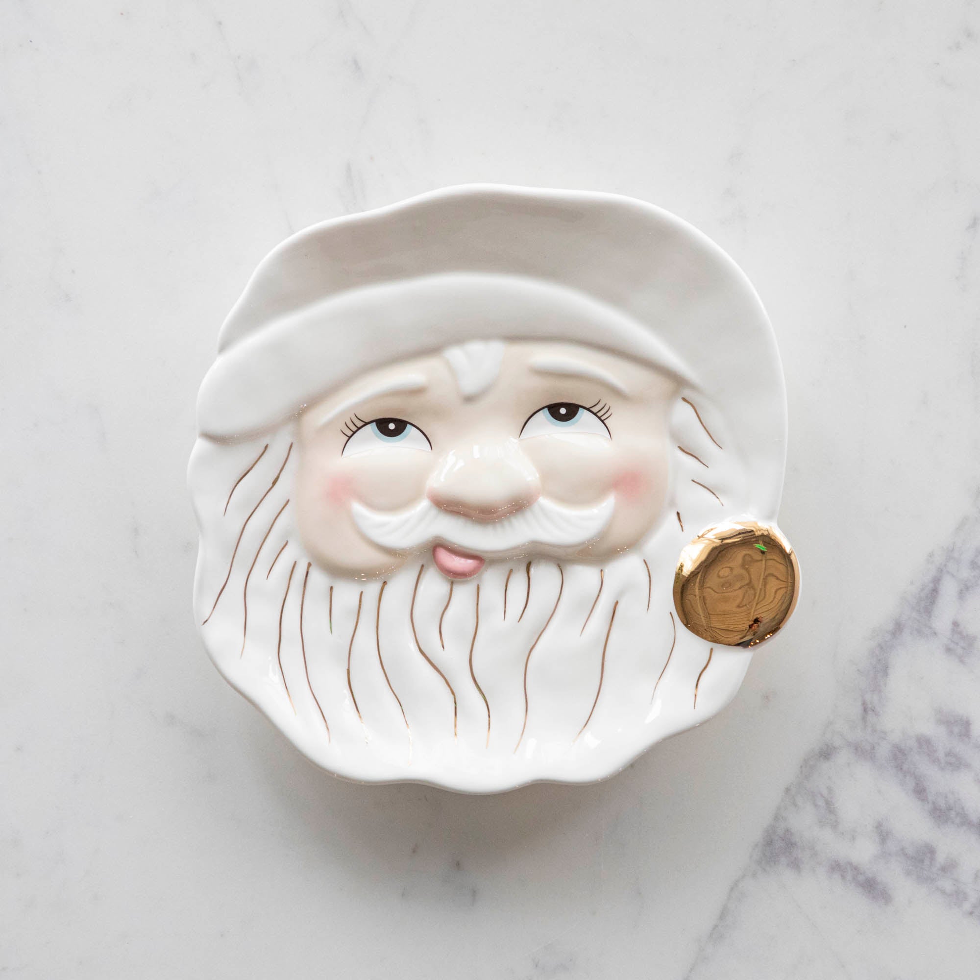 The Papa Noel Cream Cookie Plate with his eyes open, a jolly face, rosy cheeks and hand-painted gold details.