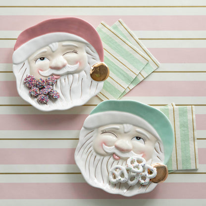 Two ceramic plates with Mint or Pink Papa Noel faces on them by Glitterville.