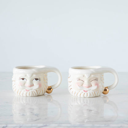 Two Cream Papa Noel Mugs.  One with his eyes open and one with them closed.