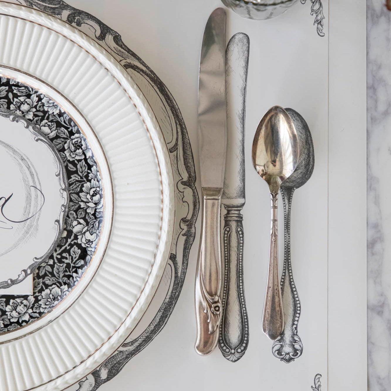 Perfect Setting Placemat with vintage silverware on top and a place setting for one.