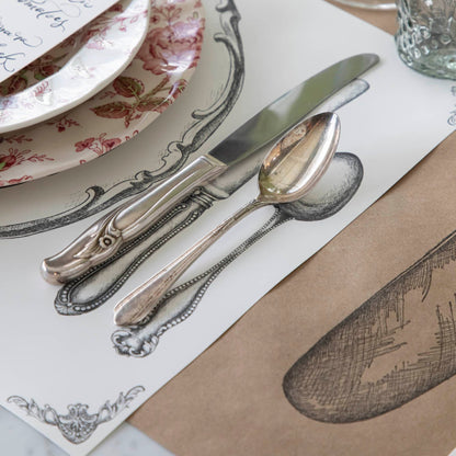 Perfect Setting Placemat with a vintage knife and spoon, offset on the placemat next to their respective knife and spoon drawing.