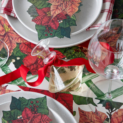 The Mouth Blown Clear Vase with wine and a red ribbon tied around the neck, on a Poinsettia themed table.