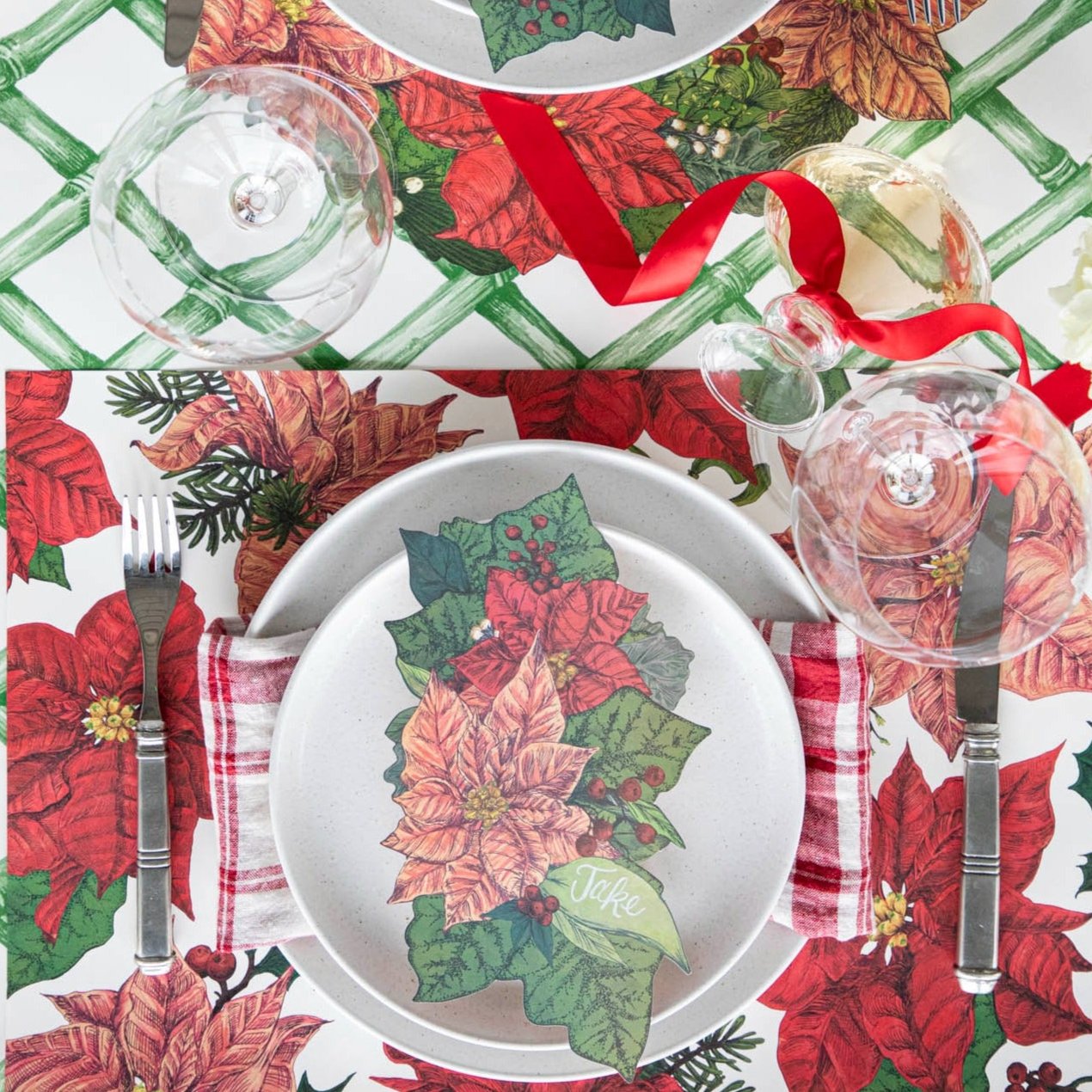 An elegant table setting with the Poinsettia Table Accent with &quot;Jake&quot; written on it, resting on Salt Dinner Plates and the Poinsettia Placemat, with the Green Lattice Runner underneath.