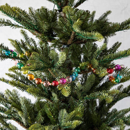 Small ball, Blown Glass Rainbow Garland draped on a tree.