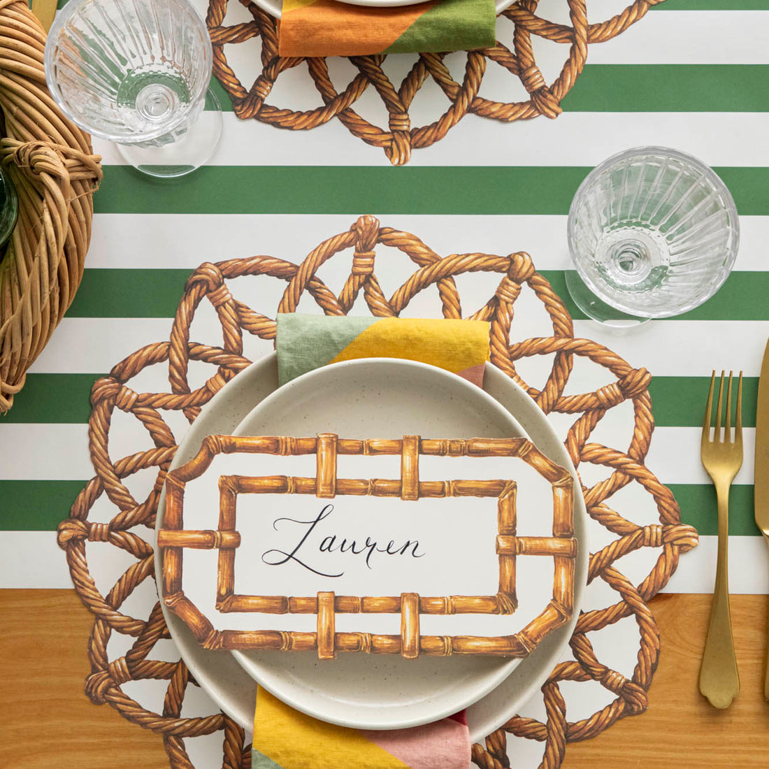 Die-cut Rattan Weave Placemat under dinner plates on an elegant table setting for one.