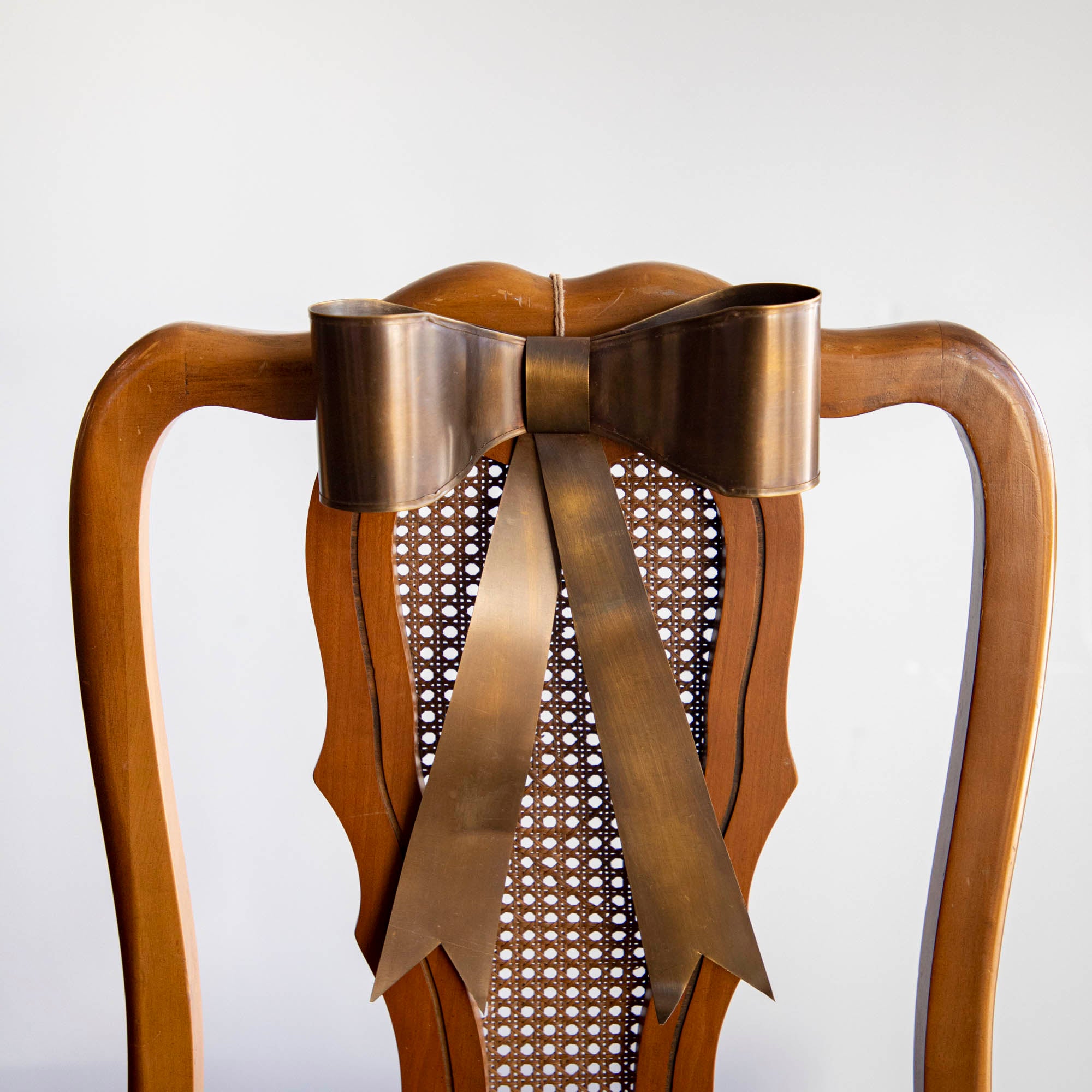 Single Brass Bow on back of chair