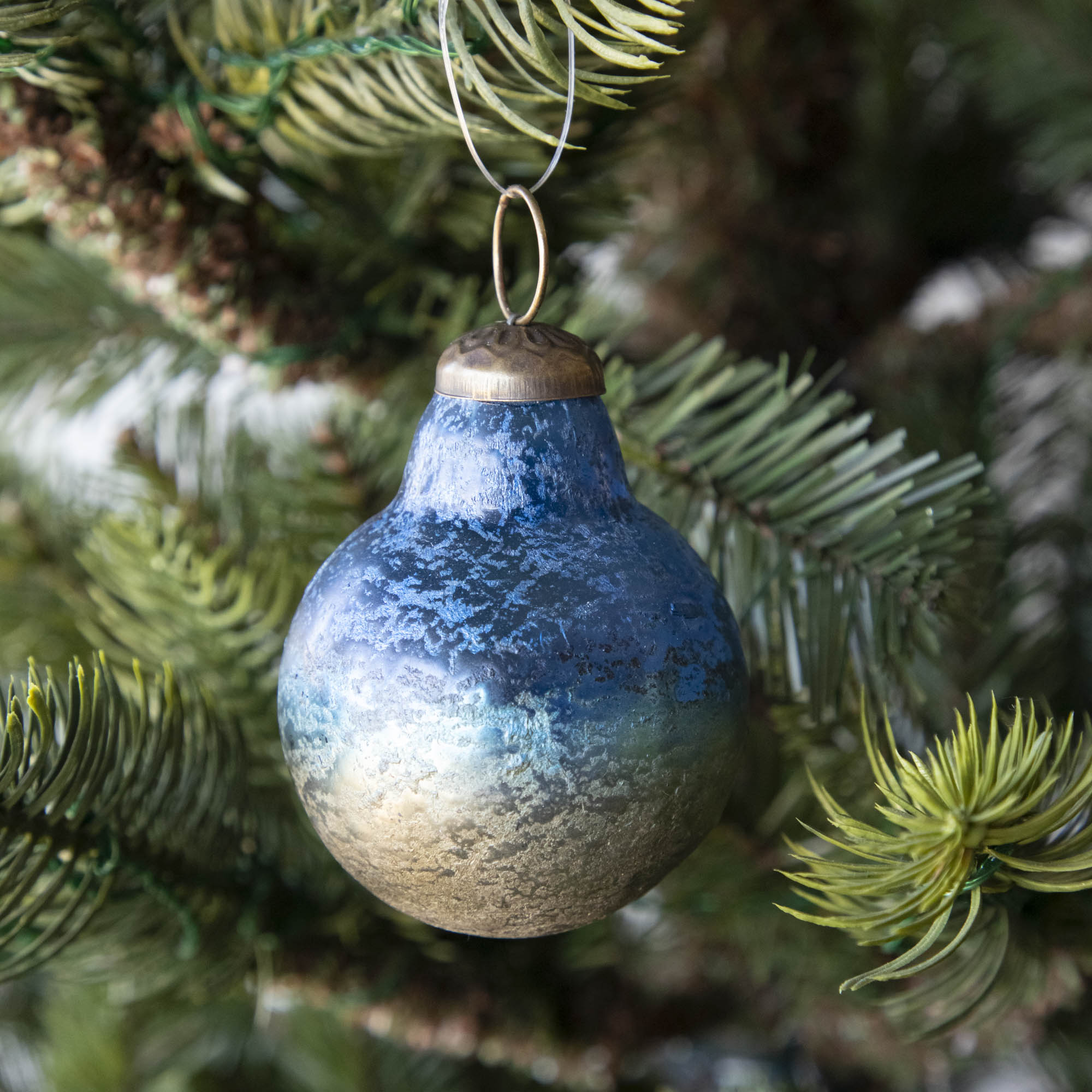 Blue Kugel Ornament hanging in a tree