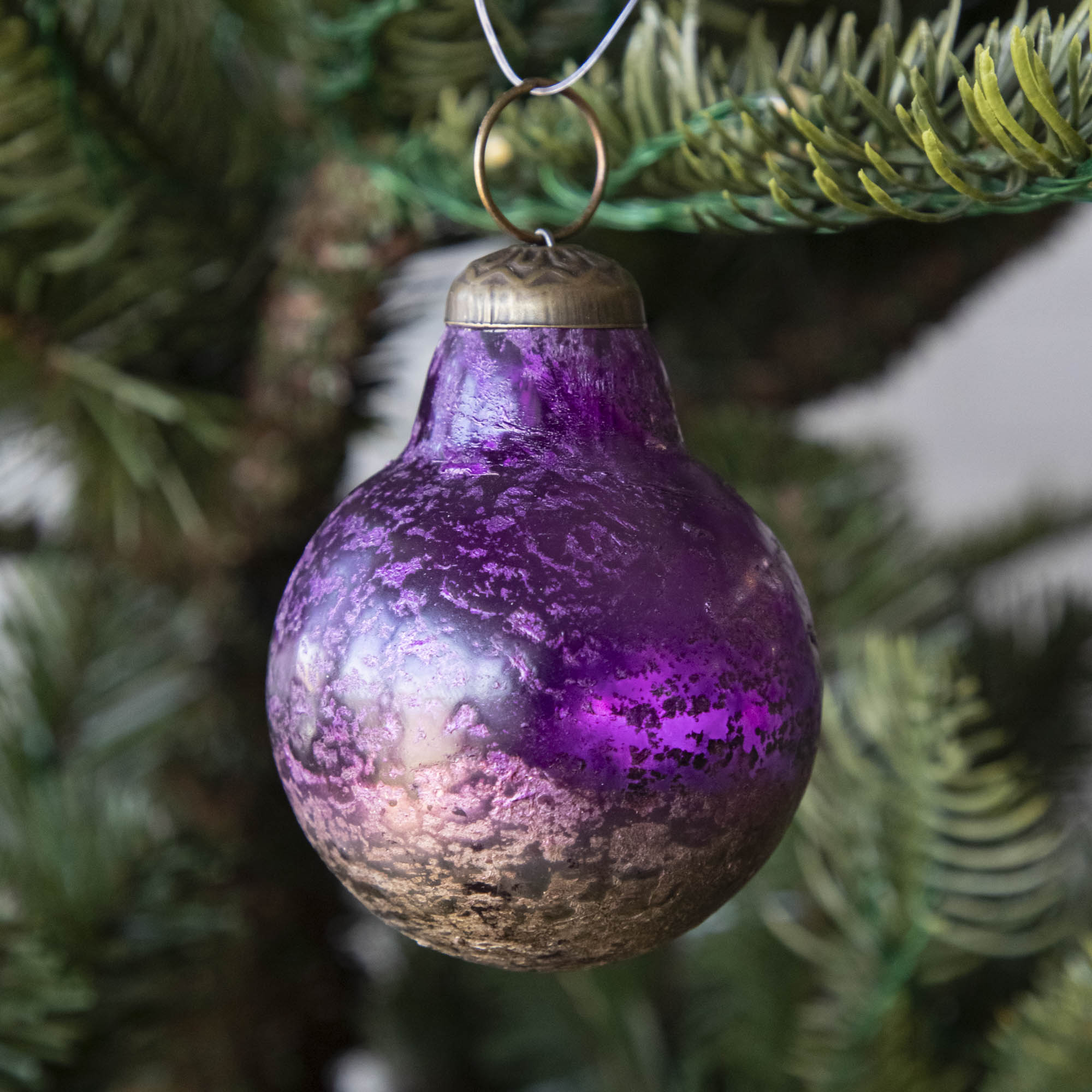 Purple Kugel Ornament hanging in a tree