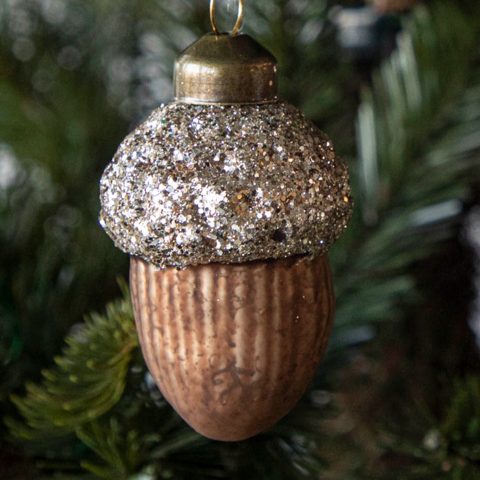 Glass ornament in the shape of an acorn with a glittered top