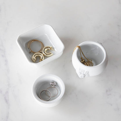 Three White Porcelain Mini Bowls with assorted spices and a spoon on a marble surface by BIA.