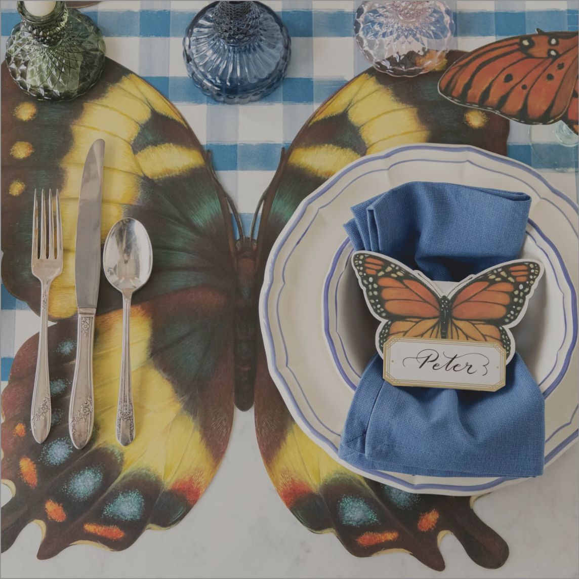 Butterfly placemat on a blue painted check runner set with butterfly accessories for spring. 